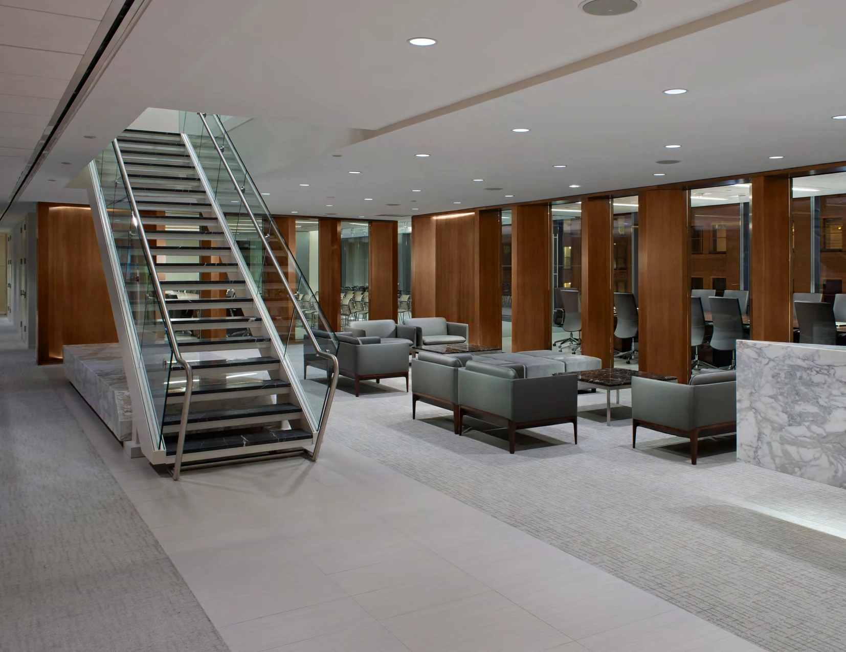 Light-filled workplace lounge with wood-paneled walls and an open staircase at the National Association of Manufacturers